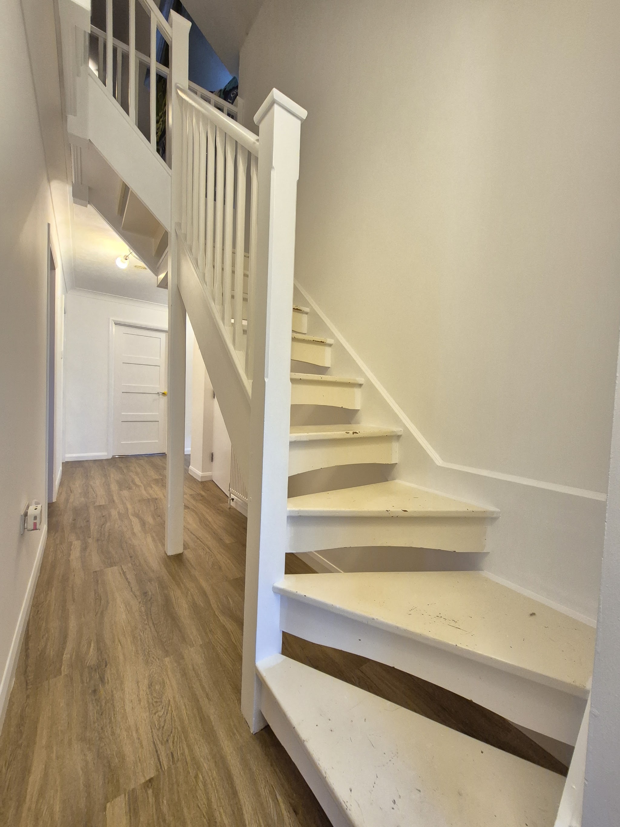 Hallway with a white painted winding staircase