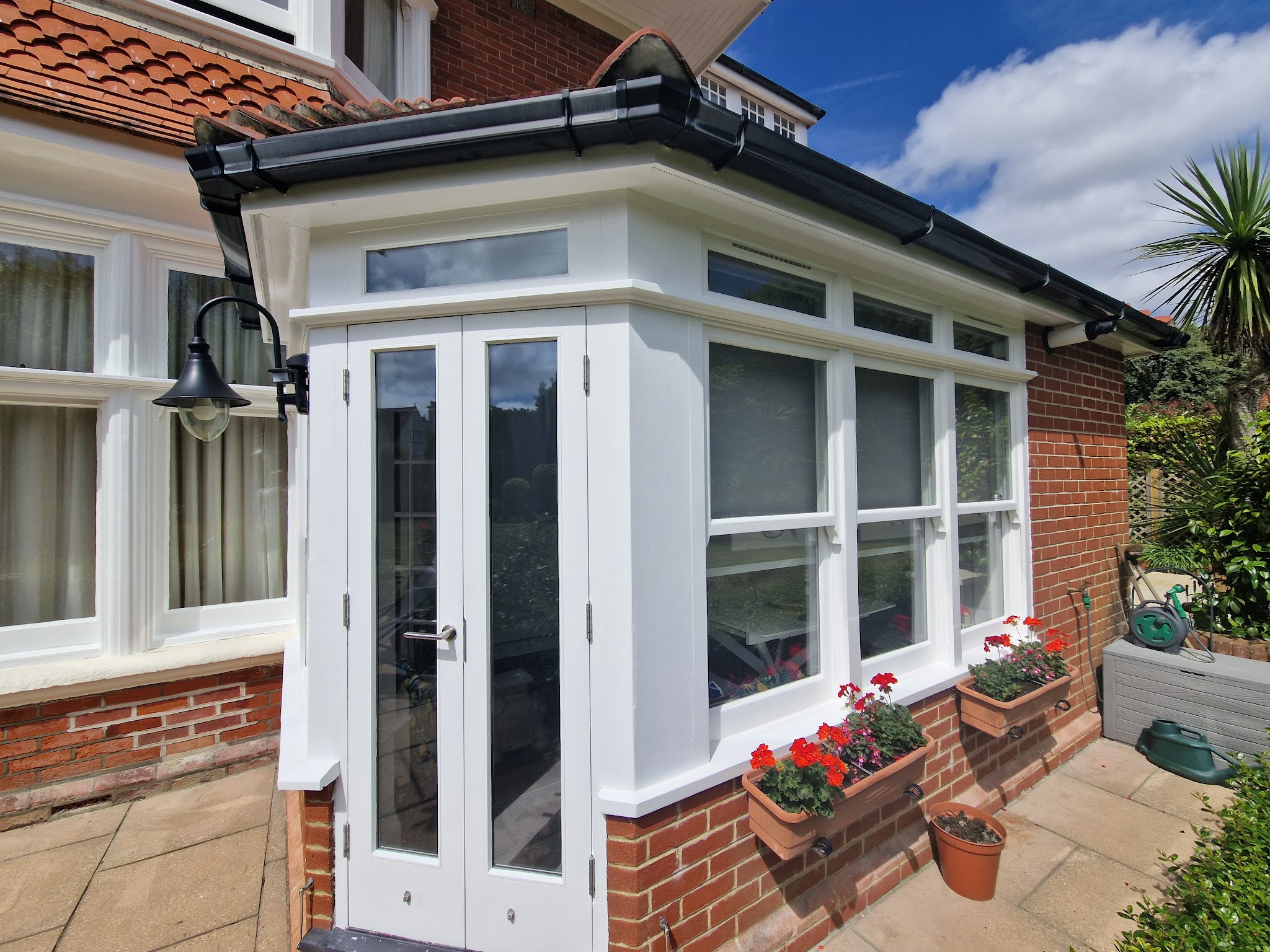 White painted porch with French doors on a red brick house