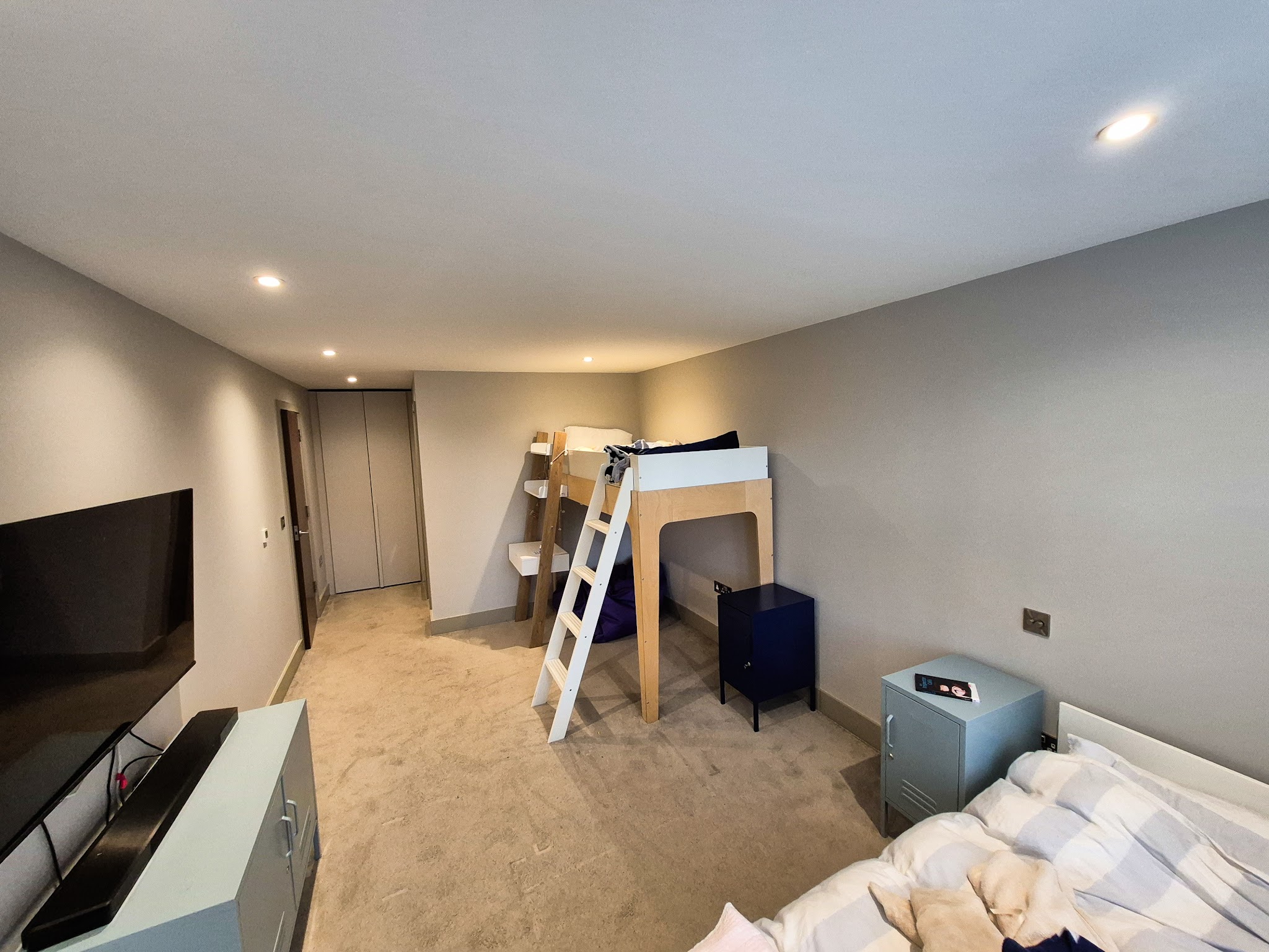 Bedroom painted soft grey with a white ceiling and downlights